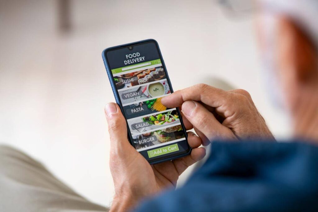 Man using a mobile phone to order food online on a restaurant website